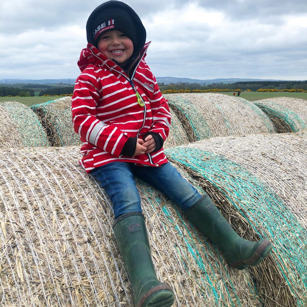 kid on a hay bale